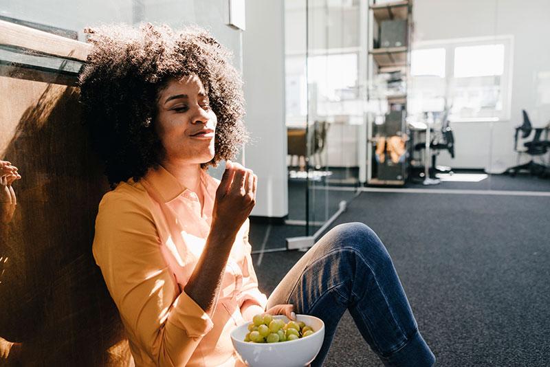 woman snacking in office at work