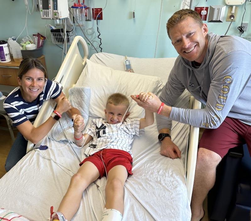 Oscar Stuebe (center) with his parents, Riley and Sarah, after he woke up in the hospital. (Photo courtesy of Sarah Stuebe)